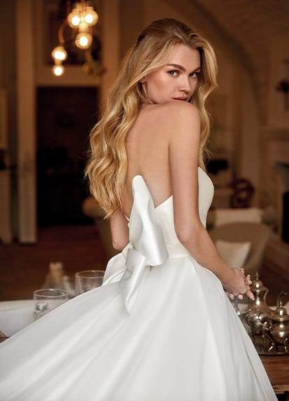 Premium Photo | Beautiful bride posing in wedding dress in a white photo  studio, mirror and sofa.